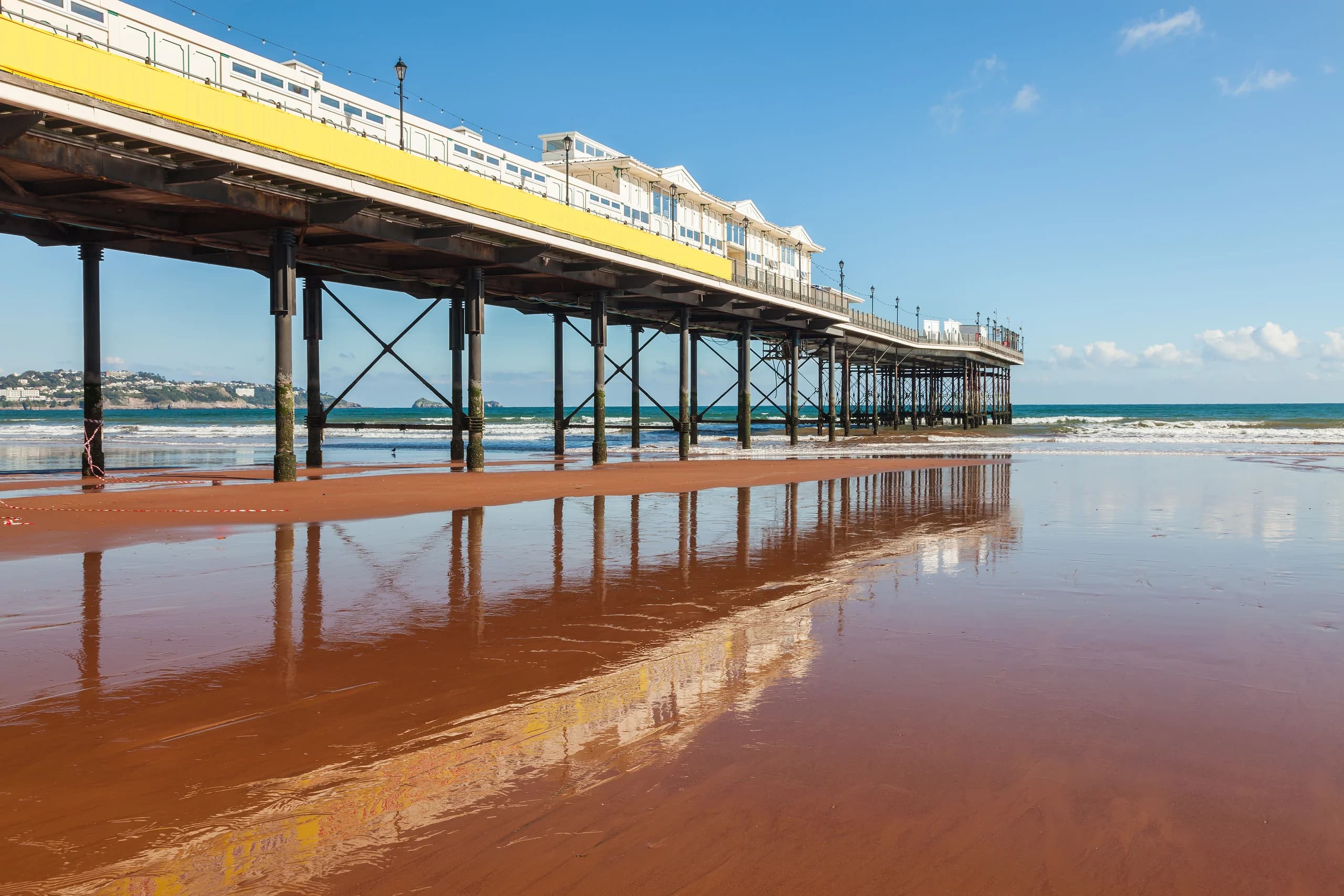 Paignton pier reflected in the red sand at low tide